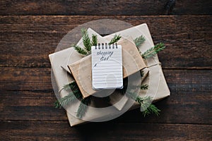 Budget Christmas, budget-friendly Christmas, Xmas Money Saving Tips. Very small shopping list in open notebook on gift