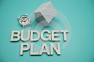Budget Plan alphabet letters with House Model and Clock on blue background