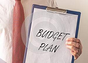 Budget plan text on paper board in businessman hands