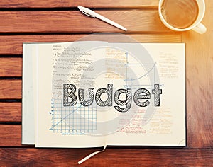 Budget : text inside notebook on table with coffee