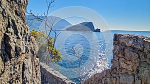 Budva - Idyllic walk along steep high cliffs to the central beach Mogren of coastal tourist city of Budva, Montenegro