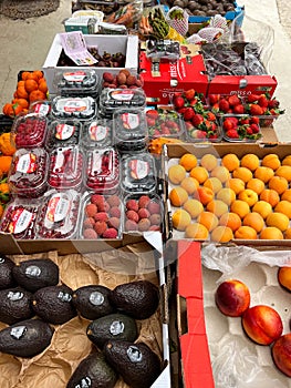 Budva, Montenegro - 25 december 2022: Avocados, peaches, lychee berries, raspberries, strawberries lie in boxes on the