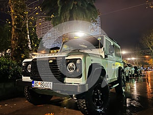 Budva, Montenegro - 25 december 2022: White SUV stands in the parking lot under a street lamp. Logo: Land Rover