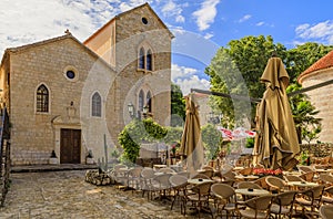 Picturesque square with a restaurant and the Holy Trinity church in the Old town in Budva Montenegro in the Balkans