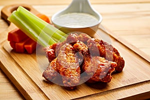 Buffalo Chicken wings with dip served in dish isolated on wooden table top view of starter fastfood appetizer food