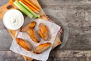 Buffalo spicy chicken wings with cayenne pepper sauce on wooden table