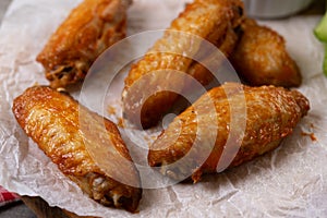 Buffalo spicy chicken wings with cayenne pepper sauce on wooden table.