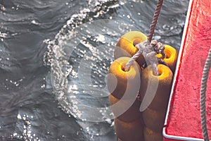 Buffer buoys on boat sides with sunlight reflection on water