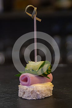 Buffet canape with soft cheese, ham and cucumber rolls