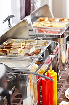 Buffet heated trays ready for service. Breakfast in hotel smorgasbord.