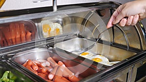 Buffet heated trays with sausages, boiled broccoli and fried eggs in hotel luxury restaurant. All inclusive. Buffet food