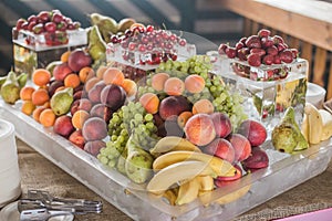 Buffet line assorted Fruit platter of strawberries Grapes Blueberries Peaches Apricot Banana Cherry Pears on ice. View