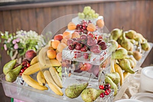 Buffet line assorted Fruit platter of strawberries Raspberry Grapes Blueberries Peaches Apricot Banana Cherry Cherries