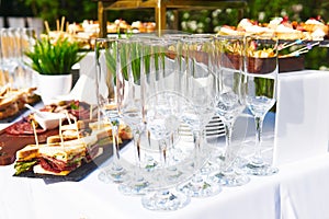 Buffet in the open air - empty glasses on the background of cold snacks on the table