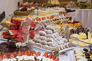 Buffet with sweets. fruits and other sweets on dessert table. Rows of tasty looking desserts in beautiful arrangements. Sweets on