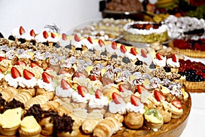 Buffet with sweets. fruits and other sweets on dessert table. Rows of tasty looking desserts in beautiful arrangements. Sweets on
