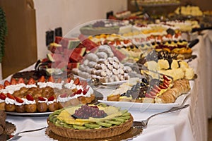 Buffet with sweets. fruits and other sweets on dessert table. Rows of tasty looking desserts in beautiful arrangements. Sweets on