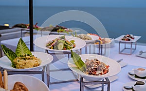 Buffet table by the ocean with fresh salad and bread