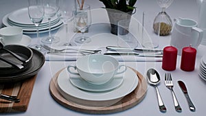 Buffet table setting, serving tableware on the table, white plate fork and knife.
