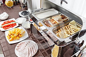 Buffet trays heated ready for service. Breakfast in hotel smorgasbord. Plates with different food