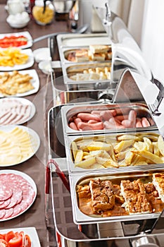 Buffet trays heated ready for service. Breakfast in hotel smorgasbord. Plates with different food