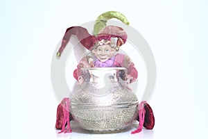 Buffoon toy holding silver shining jug