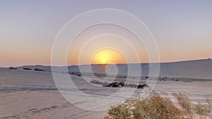 Buggies in sand desert at the sunset timelapse