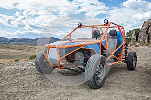 Buggy on the ground against the backdrop of a mountain landscape