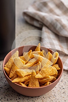 Bugles snack. Cone corn chips in bowl on kitchen table