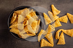 Bugles snack. Cone corn chips in bowl on kitchen table. Top view