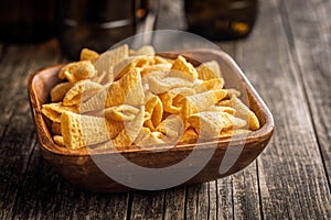 Bugles snack. Cone corn chips in bowl on wooden table