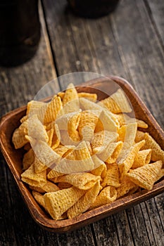 Bugles snack. Cone corn chips in bowl on wooden table