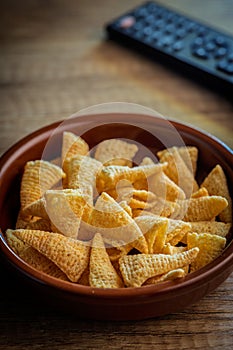 Bugles snack. Cone corn chips in bowl on wooden table