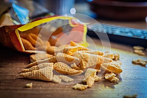 Bugles snack. Cone corn chips on wooden table