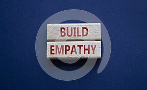 Build empathy symbol. Wooden blocks with words Build empathy. Beautiful deep blue background. Psychology and Build empathy concept