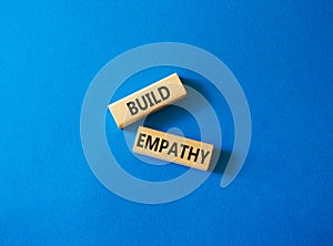 Build empathy symbol. Wooden blocks with words Build empathy. Beautiful blue background. Psychology and Build empathy concept.