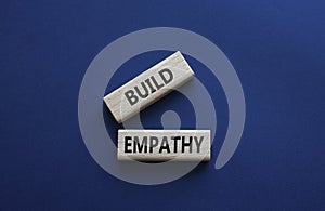 Build empathy symbol. Wooden blocks with words Build empathy. Beautiful deep blue background. Psychology and Build empathy concept