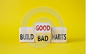 Build Good or Bad Habits symbol. Wooden cubes with words Build Bad Habits vs Build good Habits. Beautiful yellow background.