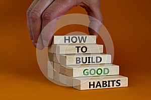 Build good habits symbol. Wooden blocks with words `how to build good habits`. Businessman hand. Beautiful orange background, co
