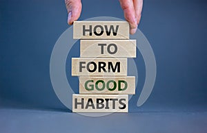 Build good habits symbol. Wooden blocks with words `how to form good habits`. Male hand. Beautiful grey background, copy space.