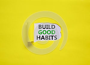 Build good habits symbol. Words `Build good habits` appearing behind torn yellow paper. Beautiful yellow background. Business,