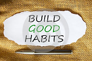 Build good habits symbol. Words `Build good habits` on white paper. Black metallic pen. Beautiful canvas background. Business,