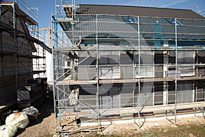 build a new house out of concrete with scaffolding next to the walls to get access to every level of the building and be able to