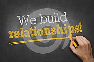 We build relationships - hand writing business concept on chalkboard