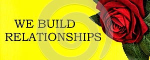 We build relationships - text inscription on the background of a red rose.