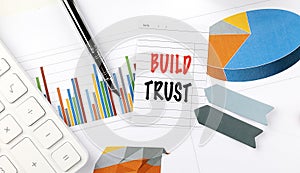 BUILD TRUST text on note paper on chart background