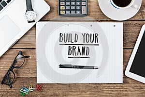 build you brand on notebook on Office desk with computer technology, high angle
