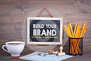 Build Your Brand concept. Trust Design Strategy Marketing. Chalkboard on a wooden background