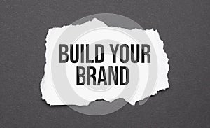 Build Your Brand sign on the torn paper on the black background
