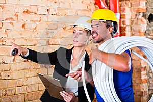 Builder and architect working on construction site